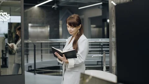 Female designer browsing tile options at a salon and writes in a notebook Stock Footage 276620415