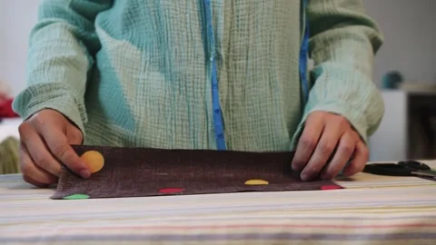 A female designer cuts off a piece from the pattern and smoothes it with an iron Stock Footage 255044087