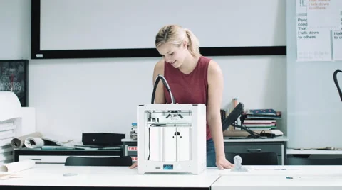 Female designer looking at 3D printed object in design studio Stock Footage 55869428
