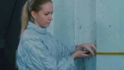 Female Designer Measuring Basement Wall Stock Footage 101368148