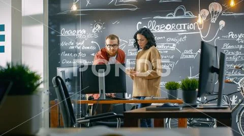 Female Designer Talks with Male Developer, They Look at Personal Computer Stock Photos