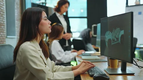 Female designer using computer to design ev car prototype at office. Stock Footage 235556893