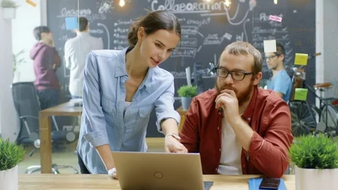 Female Designers Talks Male Developer About Ongoing Project while He Works. Stock Footage 84100203