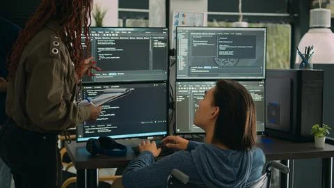 Female developer analyzing program code and talking to asian engineer Foto stock