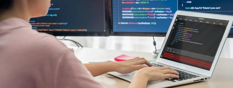Female developer coding on laptop while computer display program. Burgeoning. Stock Photos