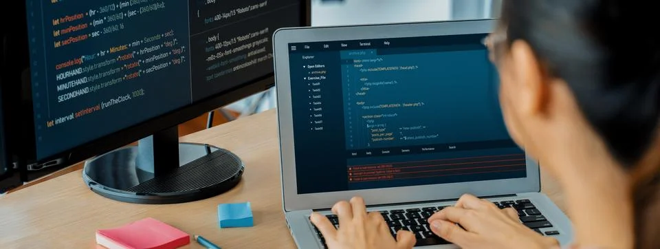 Female developer coding on laptop while computer display program. Burgeoning. 写真素材