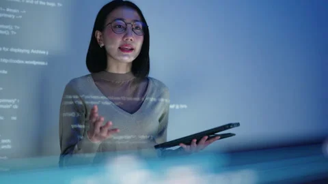 A female developer conducts a coding workshop at night, with HTML code. Stock Footage 310589071