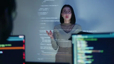 A female developer conducts a coding workshop at night, with HTML code. Stock Footage 310589078