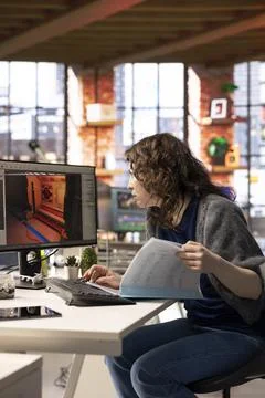 Female developer interacts with virtual AI assistant on PC to design a game hub Stock Photos