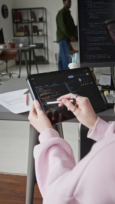 Female Developer Reviewing Script from Vibe Coding Agent on Tablet in Office Stock Footage 335941759