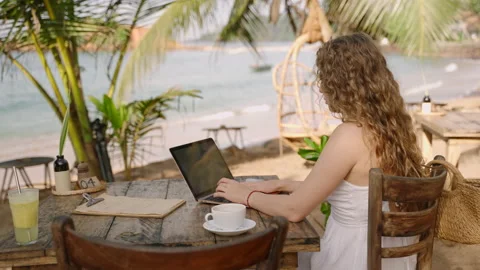 Female developer working on laptop by the ocean. Young woman freelancer coding Stock Footage 234540160