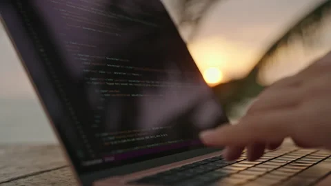 Female developer working on laptop by the ocean. Young woman freelancer coding Stock Footage 237692497