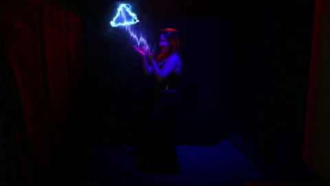 A female devil juggles an electrified pyramid and laughs. Stock Footage 122215036
