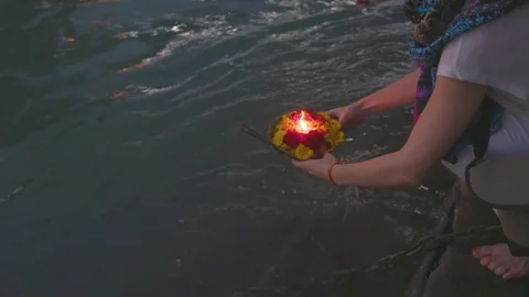 Female devotee floating her oil lamp into the Ganga Stock Footage 77454563