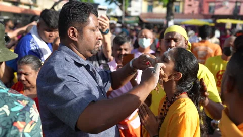 A female devotee in trance has had her cheeks skewered during Thaipusam festival Stock Footage 234047321