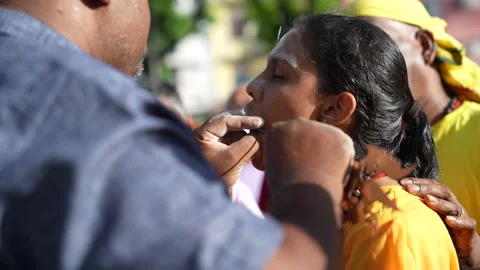 A female devotee in trance has had her cheeks skewered during Thaipusam festival Stock Footage 234047342
