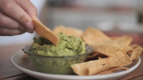 Female Dipping Corn Chip into Fresh Guacamole in Slow Motion Stock Footage 305021928