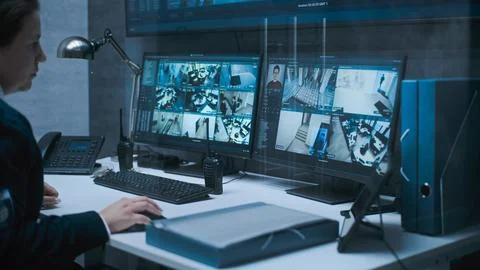 Female dispatch or CCTV operator works on computer in monitoring center 스톡 사진