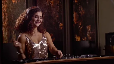 Female DJ dancing while playing on console Stockbeeldmateriaal 139977581