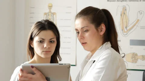 Female doc explaining something in tablet to patient Stock Footage 22968812