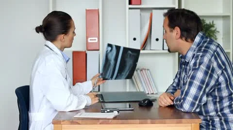 Female doctor and patient in the office looking at xray of human hand HD Stock Footage