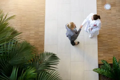 Female doctor and young woman, shaking hands, elevated view Stock Photos