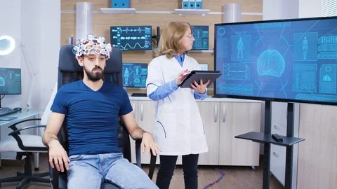 Female doctor checking the brain activity of male patient Stock Footage 119653688
