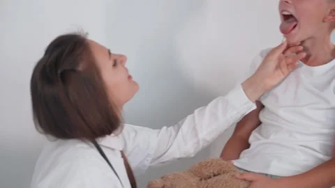 Female doctor checking lymph nodes of little boy in hospital Stock Footage 202276486