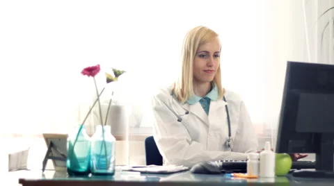 Female doctor checking working on computer and writing rx prescription HD Stock Footage 3677497