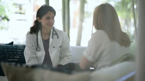 Female doctor consoling while talking to her patient in a clinic Video stock 105609460