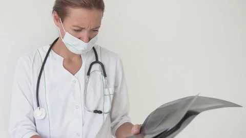 A female doctor examines X-rays of lungs with pneumonia Stock Footage 139325065