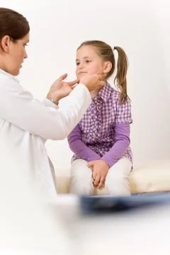 Female doctor examining child with sore throat Stock Photos