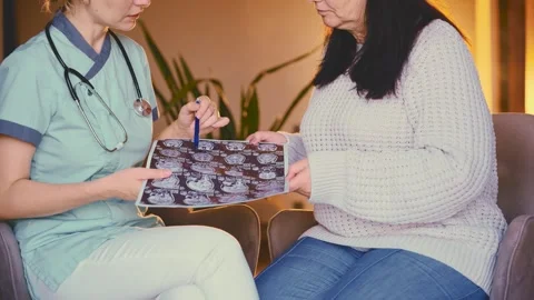 Female doctor explaining MRI scan to patient commenting on results of medical Stock Footage 312382166