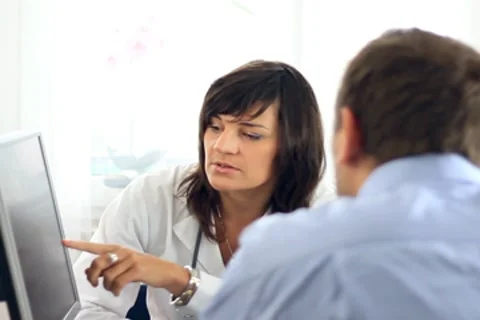 Female doctor explaining something on computer monitor to male patient NTSC 스톡 동영상 7755694