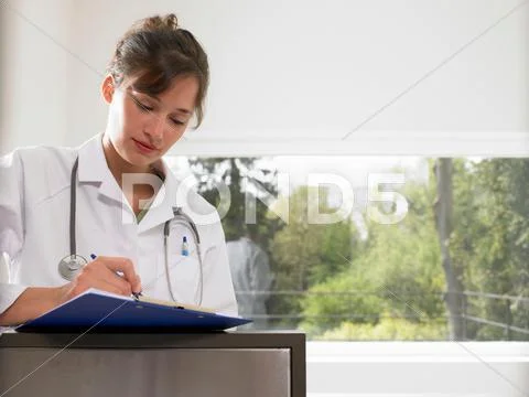 Female Doctor Filling Up A File
