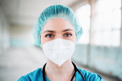 Female doctor in a green uniform with protection mask. Prevention of Covid-19. Stock Photos