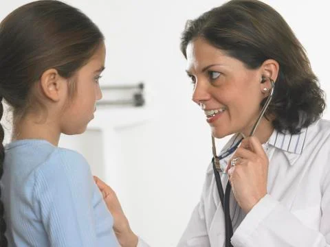 Female doctor listening to young girl's heartbeat Stock Photos