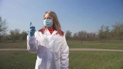 Female doctor in a mask and gloves shows how to wash hands with sanitizer Stock Footage