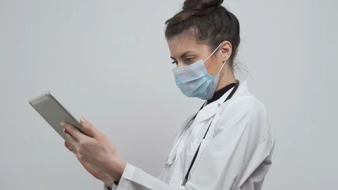 Female doctor with mask note down on paper patient symptoms. COVID-19 Stock Footage 126392563