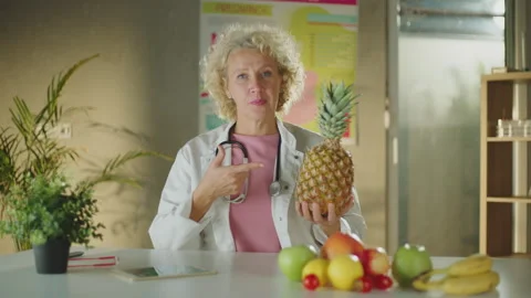 Female doctor pointing at pineapple Stock Footage 221273675