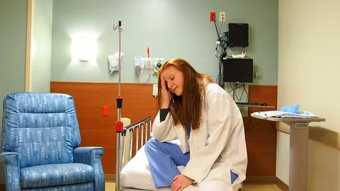 Female doctor siting on empty bed Stock Footage 70686729