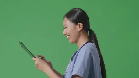 Female Doctor With Stethoscope Using A Tablet While Walking On Green Screen Stock Footage 249624258