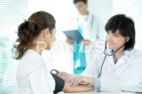 Female doctor taking blood pressure Stock Photos
