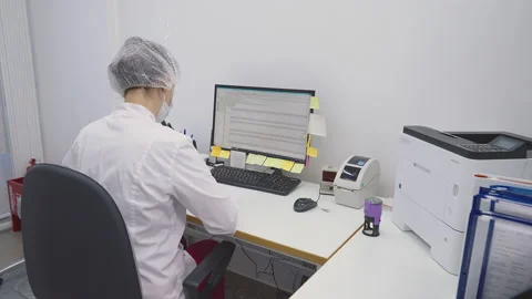 Female doctor using computer software to analyze the test results at a clinic Stock Footage 202561814