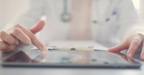 Female Doctor Using Digital Tablet And Writing In Clipboard 4K Stock Footage 92366252