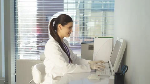 Female doctor using pc computer while sitting at work place. Stock Footage 154364799
