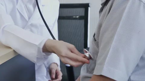 Female doctor using a stethoscope to checking lung for a male patient. Video stock 132587537