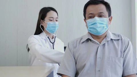 Female doctor using a stethoscope to checking lung for a middle-aged patient. Video stock 133068129