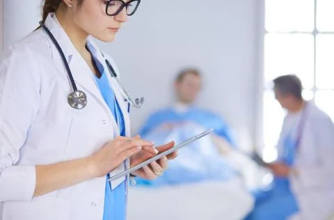 Female doctor using tablet computer in hospital lobby Stock Photos