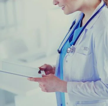 Female doctor using tablet computer in hospital lobby Stock Photos